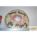 A metal advertising sign "DoNut Worry Be Happy"