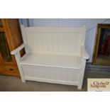 A cream painted pine bench with under seat storage