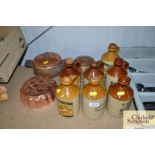 A collection of stoneware bottles, two jelly mould