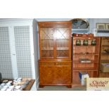 A reproduction yew wood display cabinet on covered