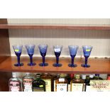 A set of six blue glass wine glasses