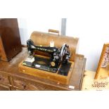 A Singer hand sewing machine in oak case (No. EC96