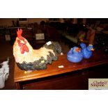 A model of a cockerel and two blue pottery bird fi