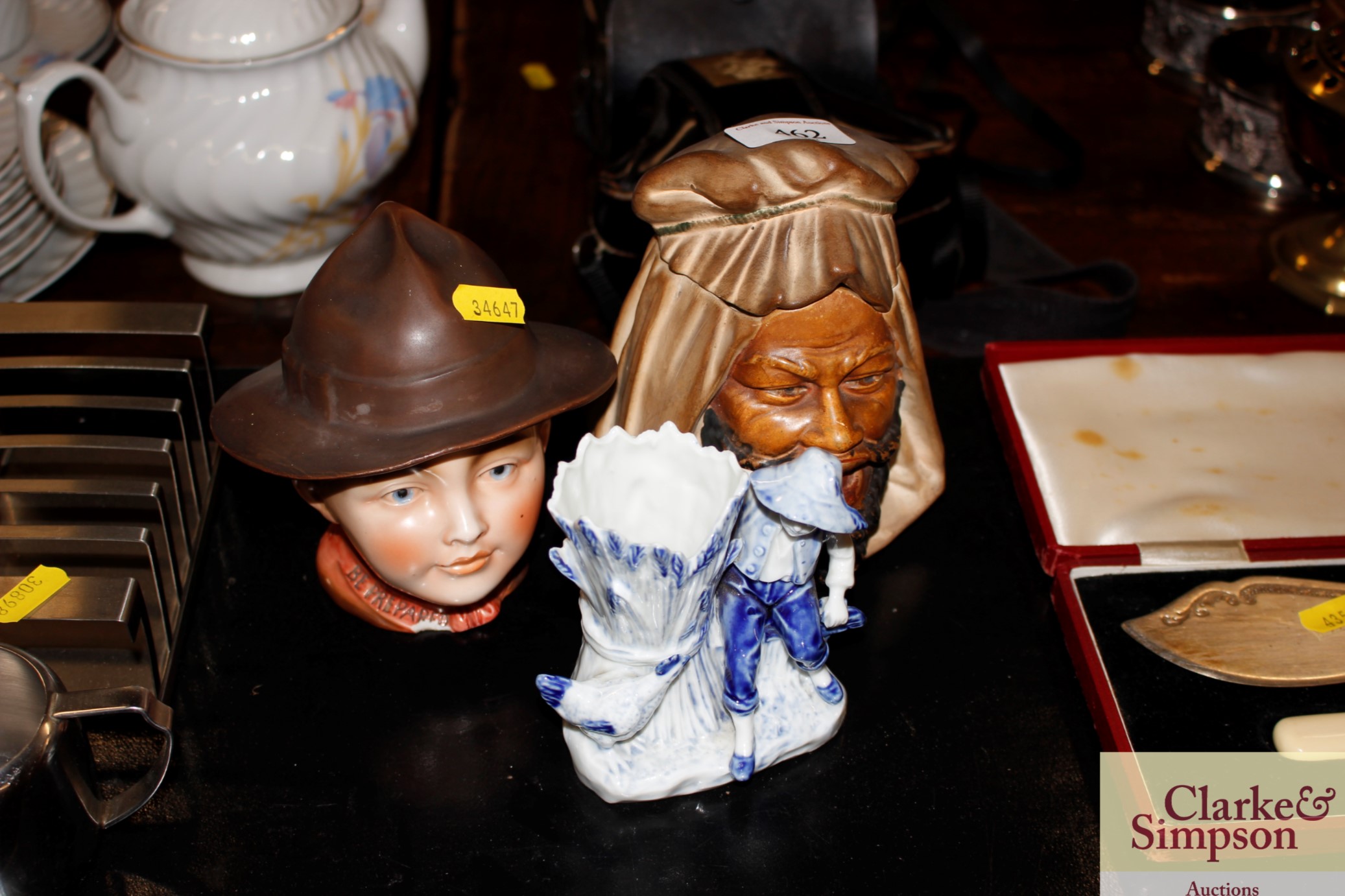 A pottery jar in the form of a Boy Scout; another in the form of a Bedouin and porcelain posy vase