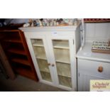 A painted pine and glazed wall cabinet