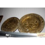 Two circular brass embossed plaques depicting tavern scenes
