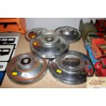 Three Jaguar hubcaps and two others