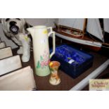 A Wade Heath Art Deco tall jug; and a Brannam ware pottery jug decorated exotic bird