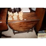 An antique elm gate leg drop leaf dining table