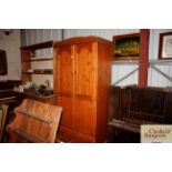 A modern pine wardrobe fitted single drawer to bas