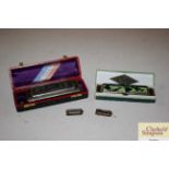 A boxed Hohner harmonica; another and two miniatur