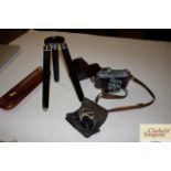 A Kodak camera in leather case; a tripod and a mon