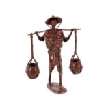 A substantial West African bronze figure of a man, with hat carrying two water buckets, 46cm high