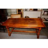 A good quality light oak refectory table, raised on turned supports and block feet united by