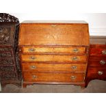 An antique oak bureau, the fall front opening to reveal an interior arrangement of drawers and
