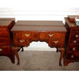 An antique walnut low boy, the cross banded overhanging shaped top above two short and two long