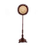 A Victorian mahogany pole screen, the circular emb