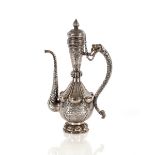 A large Tibetan finely worked white metal ewer, having beast handle, foliate and bird decoration,