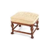 A William and Mary style oak upholstered stool, raised on a stretcher base and Spanish type feet,