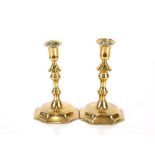 A near pair of early 18th Century brass candlesticks, with knopped stems and octagonal bases, 17.5cm