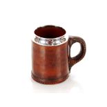 A late 19th Century brown leather "Blackjack" style tankard, with Sterling silver rim, probably by