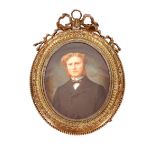 A late 19th Century oval portrait miniature, of a young gentleman contained in brass ribbon tied