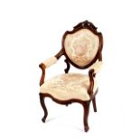 A 19th Century walnut framed salon armchair, having carved decoration, the seat, armrests and back