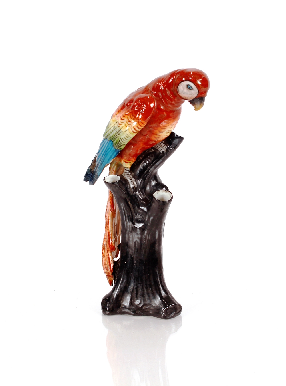 A Continental porcelain figure of a parrot, perched on tree stump, 25cm high