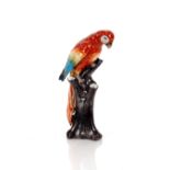 A Continental porcelain figure of a parrot, perched on tree stump, 25cm high