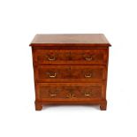 A walnut three drawer chest, having starburst motif raised on bracket supports, 78.5cm wide