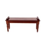 A Regency style mahogany window seat, having scroll ends raised on turned fluted supports, 111cm