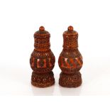 A near pair of 19th Century coquilla nut pounce pots or sanders, of lighthouse form with pierced