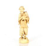 A Japanese ivory figure depicting a puppeteer, signature plaque to base, 19cm high