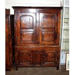 An antique oak press cupboard, the interior hanging section enclosed by four fielded panel doors