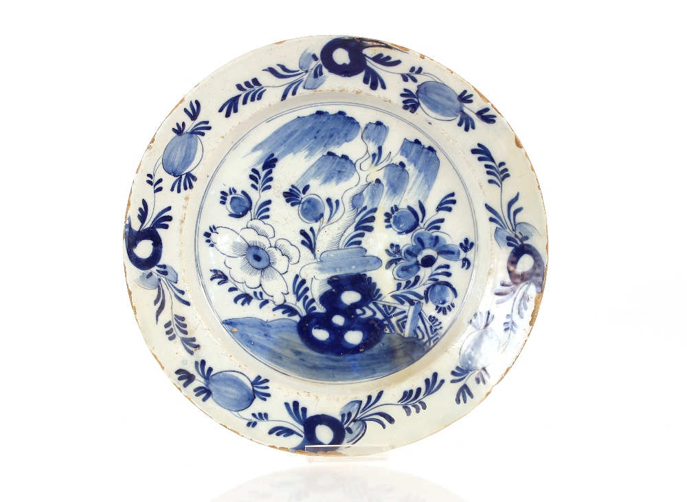 A 18th Century tin glazed blue and white charger, decorated in the Chinese style with underglaze