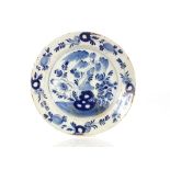 A 18th Century tin glazed blue and white charger, decorated in the Chinese style with underglaze