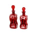 Two ruby glass decanters, of waisted form with etched decoration and globular stoppers, 21cm in