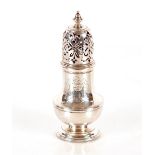 A silver baluster sugar shaker, surmounted by a finial engraved with family crest, probably London
