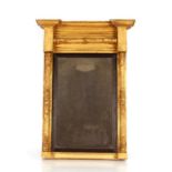 A Regency gilt framed pier mirror, having inverted breakfront pediment above scrolled pilasters