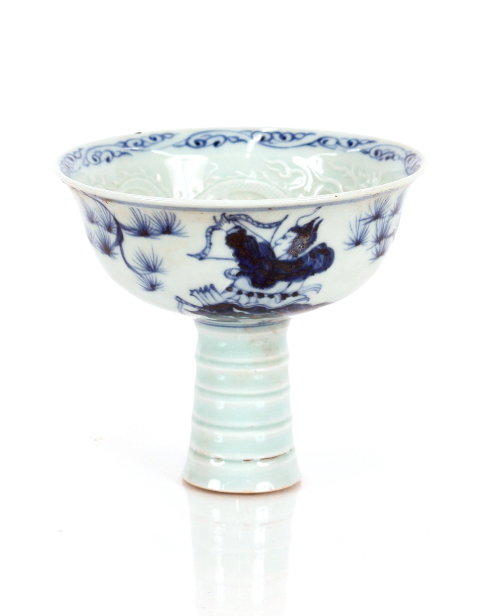 An Oriental blue and white stem cup, decorated figures and flowers with relief dragon interior, 11cm