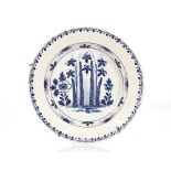 An 18th century tin glazed charger, having blue and white floral decoration within a stylised