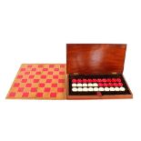 A stained bone draughts set, in mahogany case with folding board