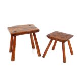 Two antique rustic elm stools, raised on rounded tapering supports