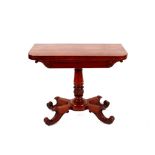 A Victorian mahogany folding tea table, the swivel top raised on a leaf carved baluster column and