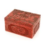 A Cinnabar type lacquered trinket box, decorated in relief with figures, foliage and symbols, 22.5cm