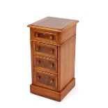 A pair of walnut and cross banded bedside chests, fitted four graduated drawers, raised on