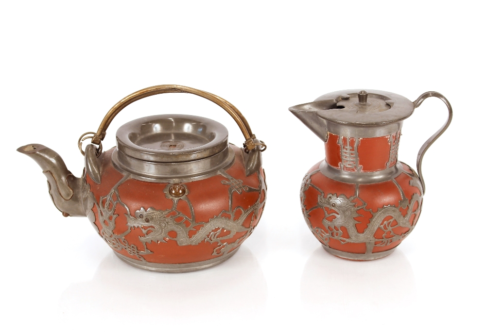 A late 19th / early 20th Century Yixing teapot, and lidded jug encased with finely worked pewter (