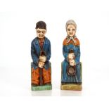 Two painted Folk Art type figures, of a seated lady with a ladle and a gentleman with walking stick,