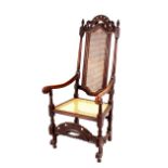 A pair of oak Carolean style high back elbow chairs, with pierced cresting's, cane panel backs and
