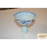 A Oriental blue and white stem cup decorated figur